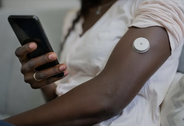 A black lady testing blood glucose with a CGM system