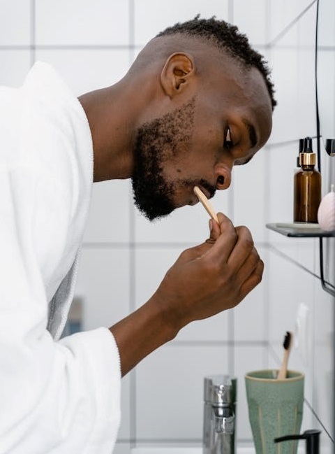 A black guy brushing his teeth in the bathroom