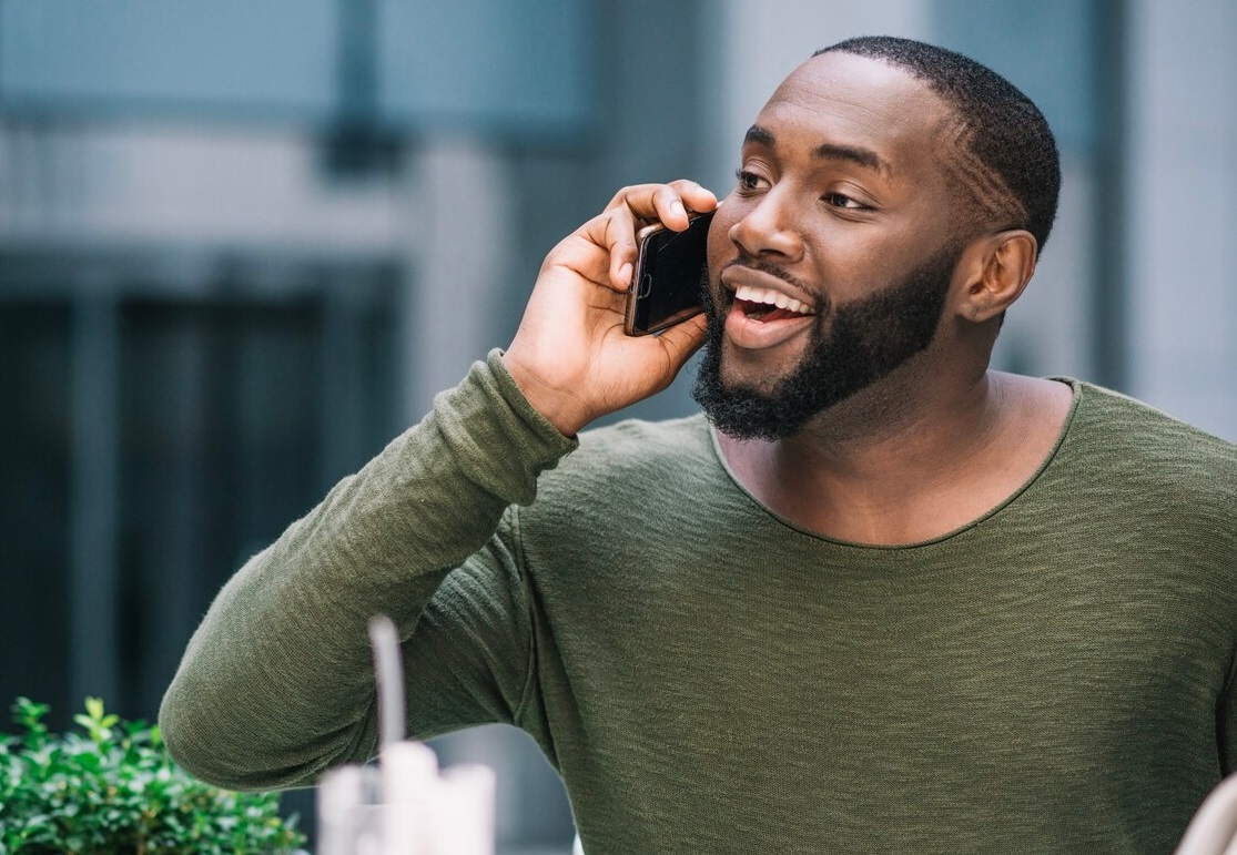 A middle aged black man speaking on a mobile phone