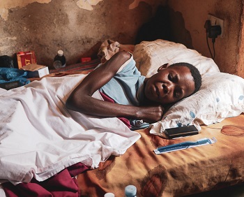 An African cancer patient who has lost weight unintentionally lying in bed at home