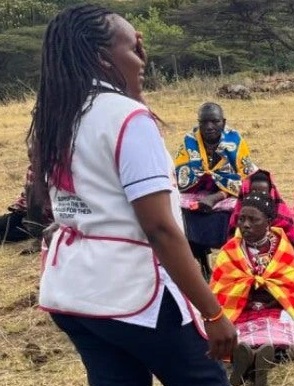 An African Community Health Nurse at work outdoors chatting with community members