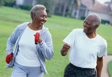 Elderly black couple brisk walking