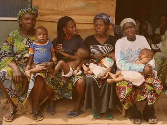 A group of African women and their babies at a health centre.