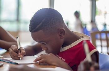 An African boy writing in a classroom