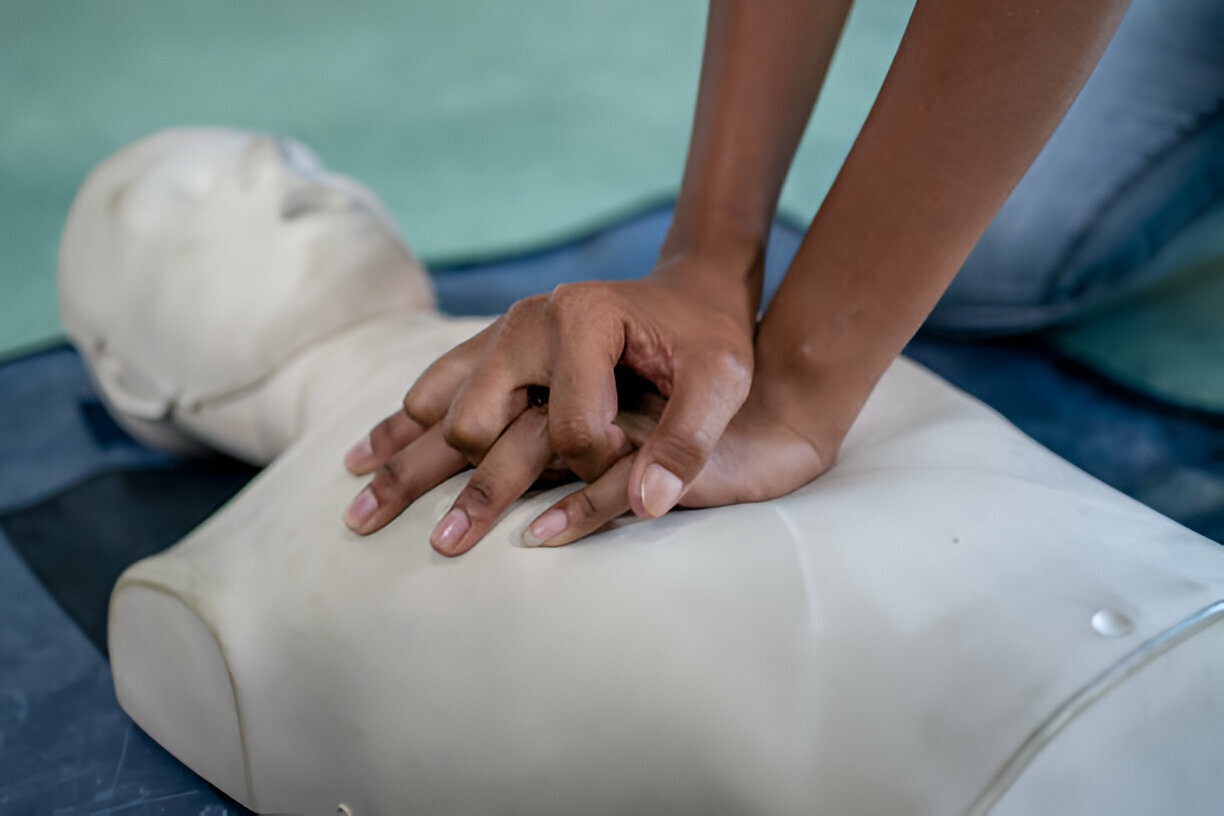 Hands on a manikin locked together during CPR demonstration
