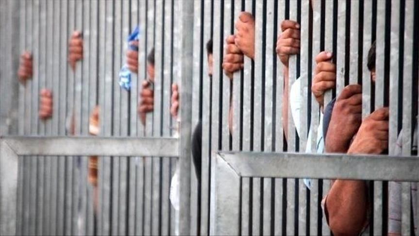 Inmates grabbing at iron bars in an overcrowded US jail