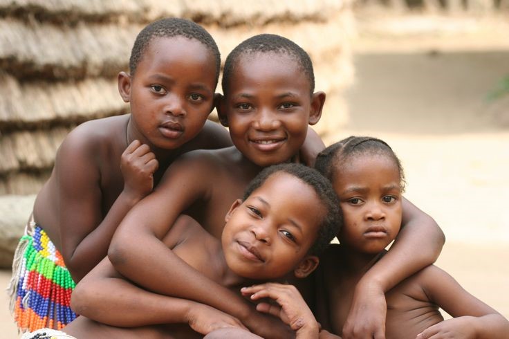 Group of bare chested African children posing together outdoors