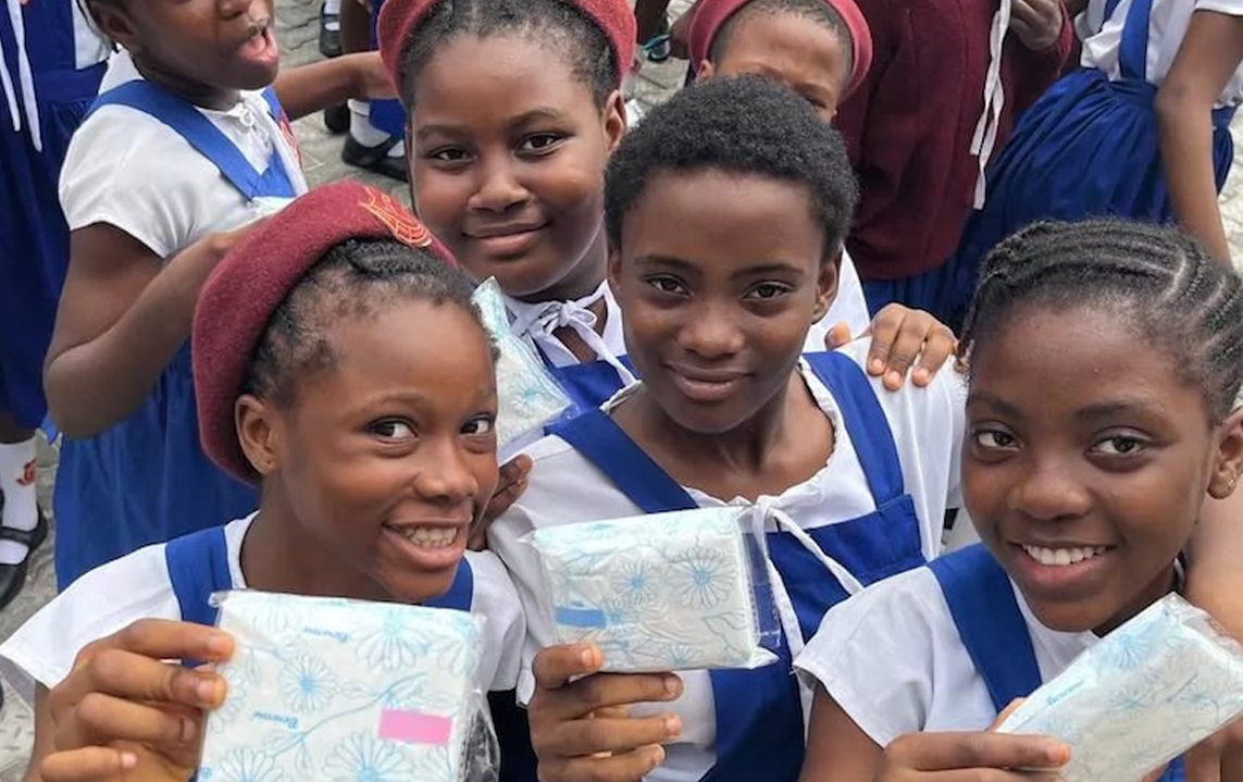 School age African girls showing off donated menstrual products