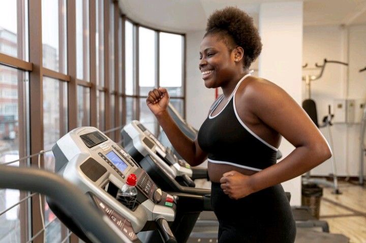 A black lady exercising on a treadmill