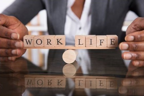 A black individual showing work-life balance sign