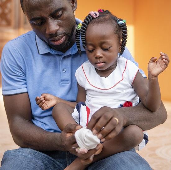 A black father holding her girl child