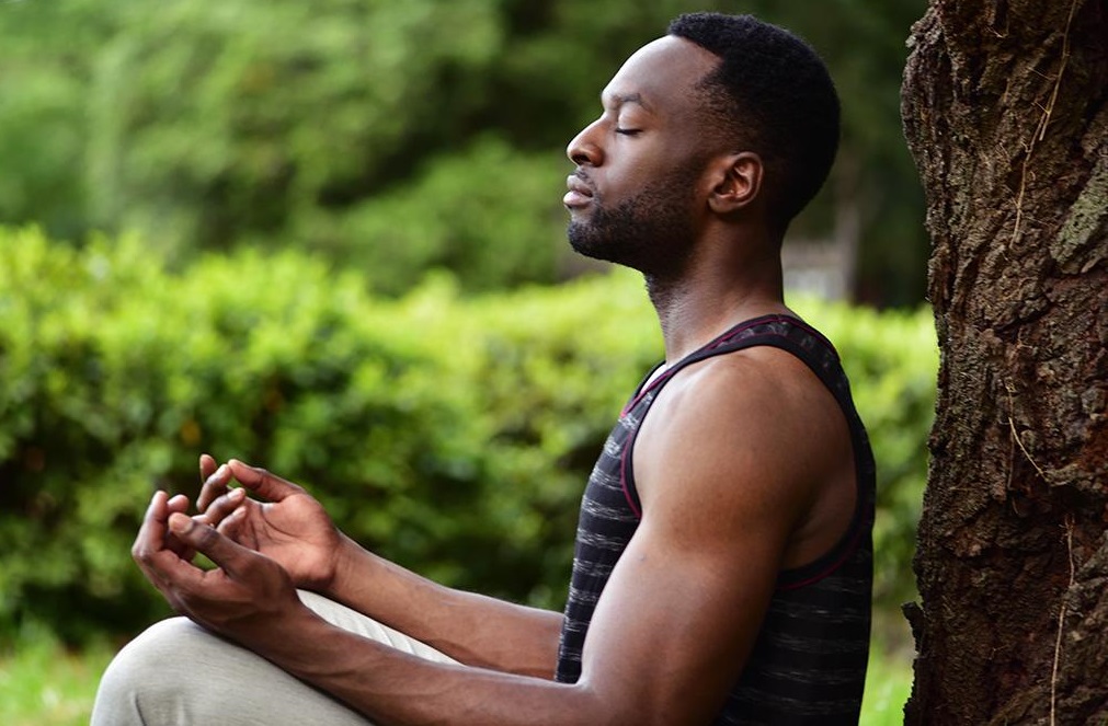 A seated black man meditation outdoor