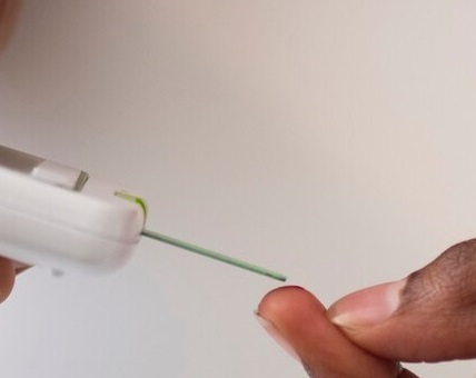 Close up of a diabetic performing finegr prick test for blood sugar level