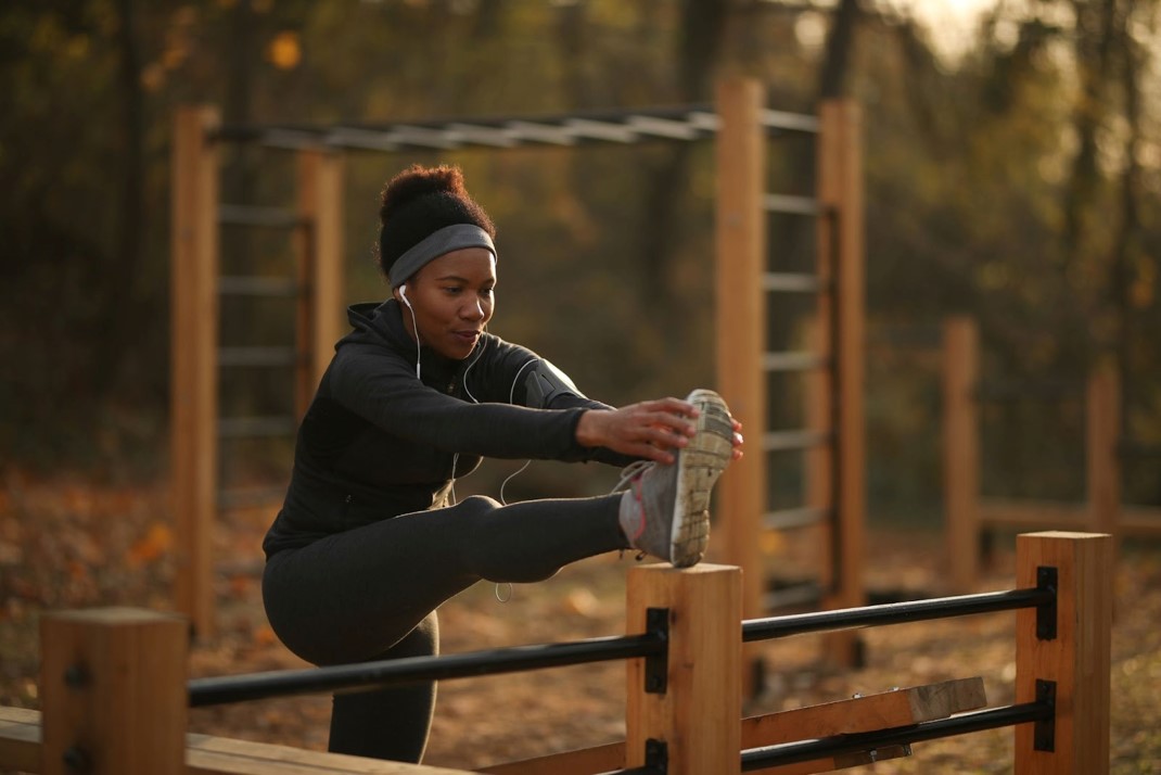 Young black girl doing raised leg stretch exercise