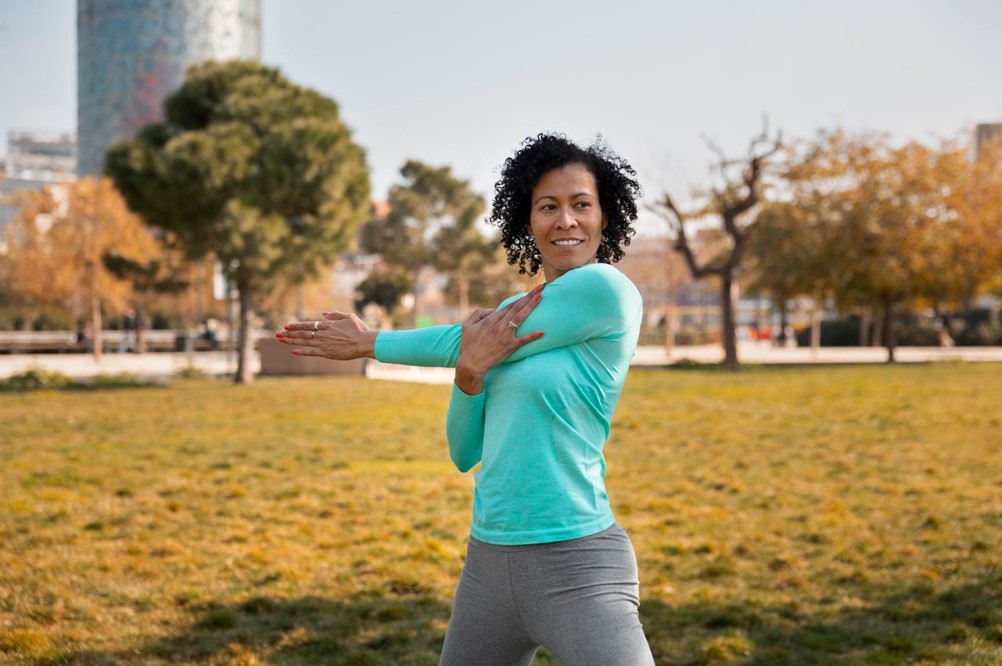 A middle aged black lady performing arm and core strengthening exercise