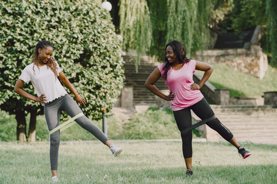 Two young girls partnering up exercising outdoor