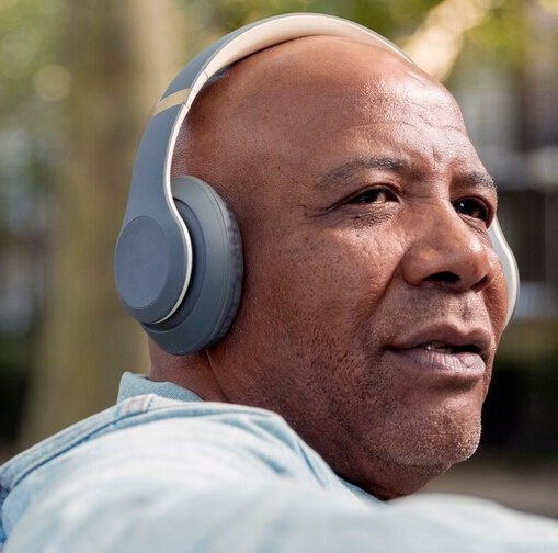 A black senior man wearing a wireless head phone