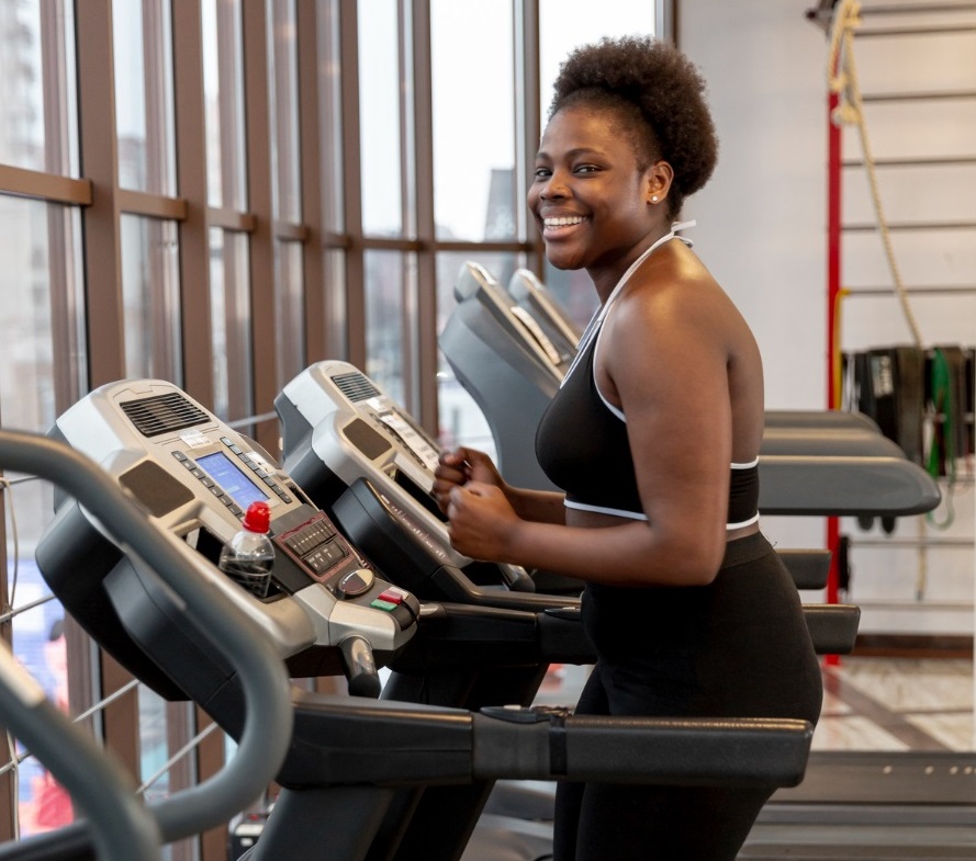 A black lady exercising on a treadmill