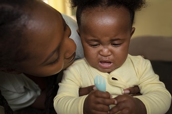 Cute black baby playing with her mother