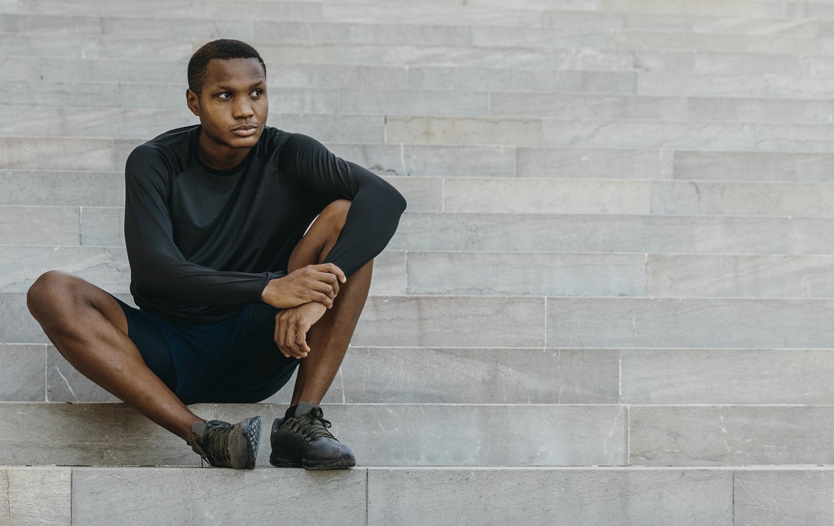 An Africa man sitting on a stirway