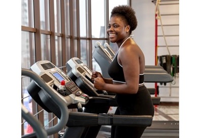 A young black woman exercising on a treadmill