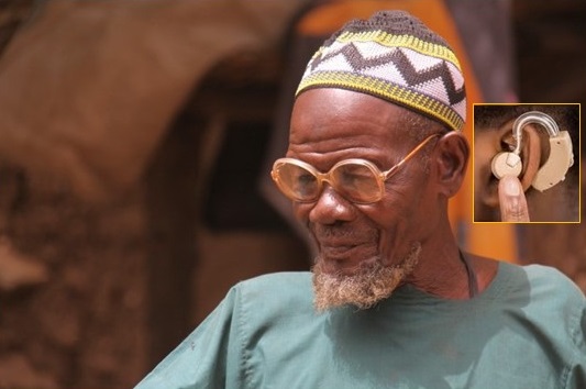 PPoto of an elderly African man seating leisurely with hearing aid inset