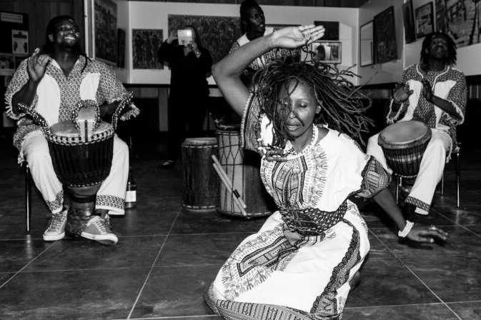 A black woman dancing to African traditional music during spiritual healing therapy